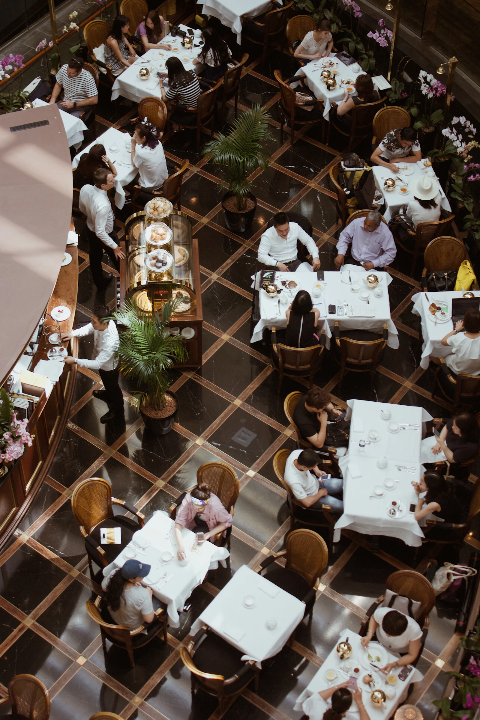 Restaurant interior with patterned floor and dining tables seen from above