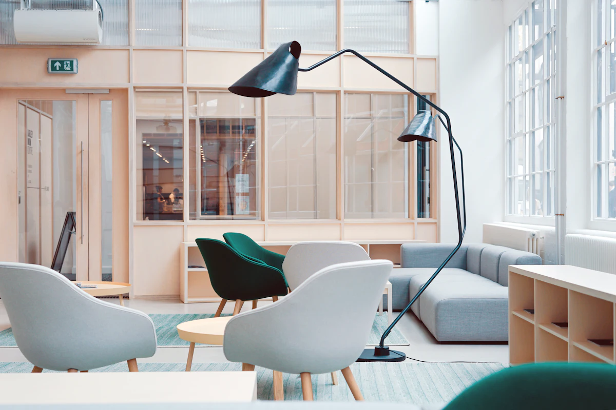 Bright collaborative office lounge with designer chairs and task lamps